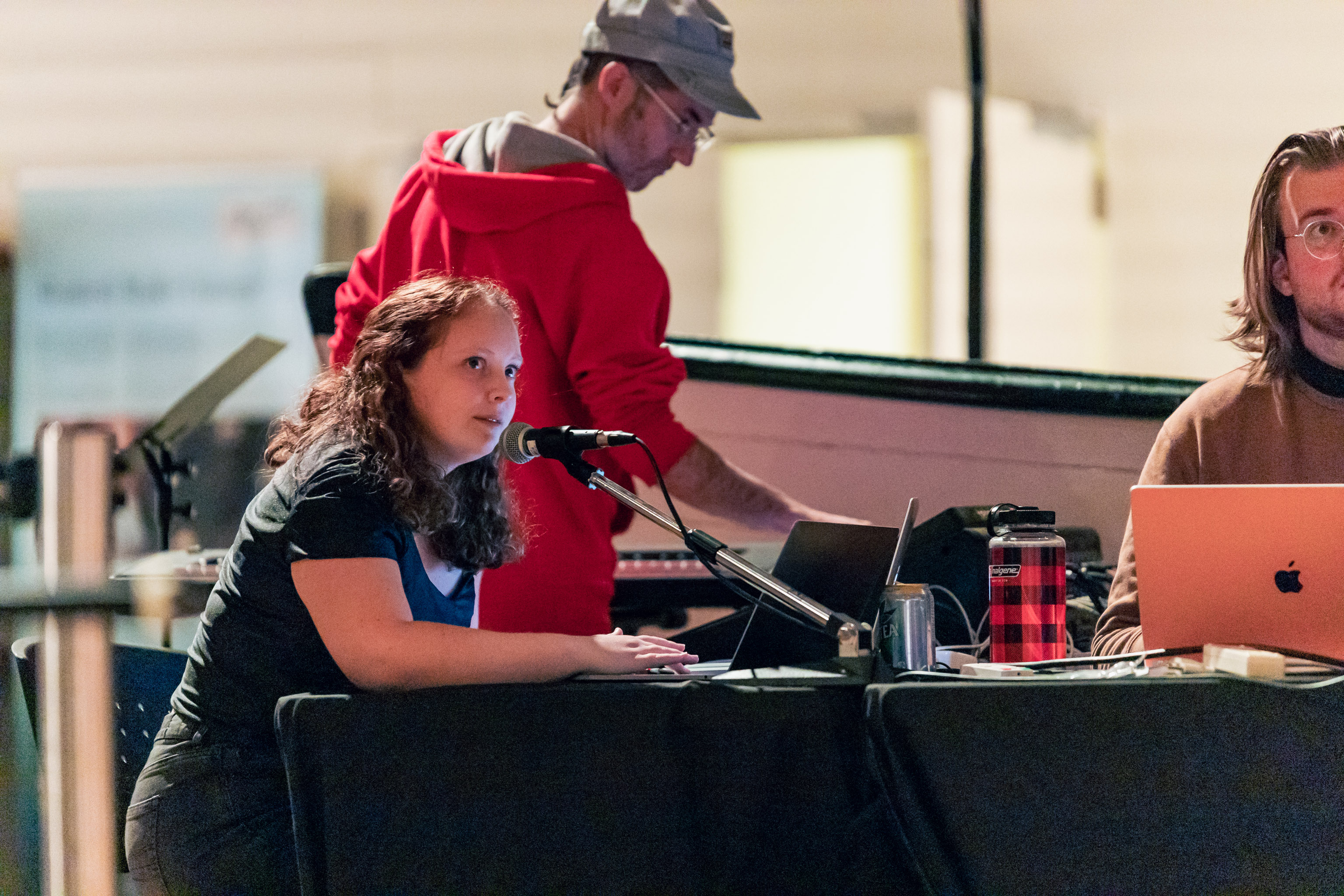 Maja Packer, Brian Riley and Christian Ludwig Hansen sitting at the technicians table, adjusting levels.