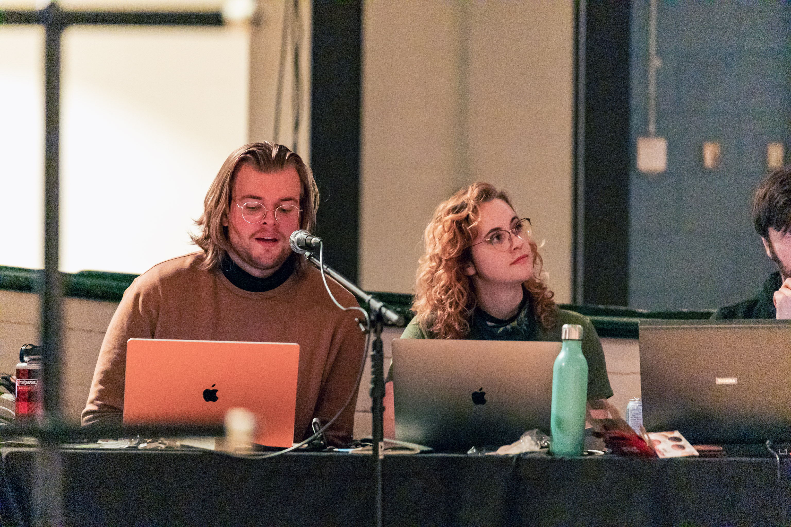 Christian Ludwig Hansen and Anna Shepherd sitting at the projections table working on surtitles