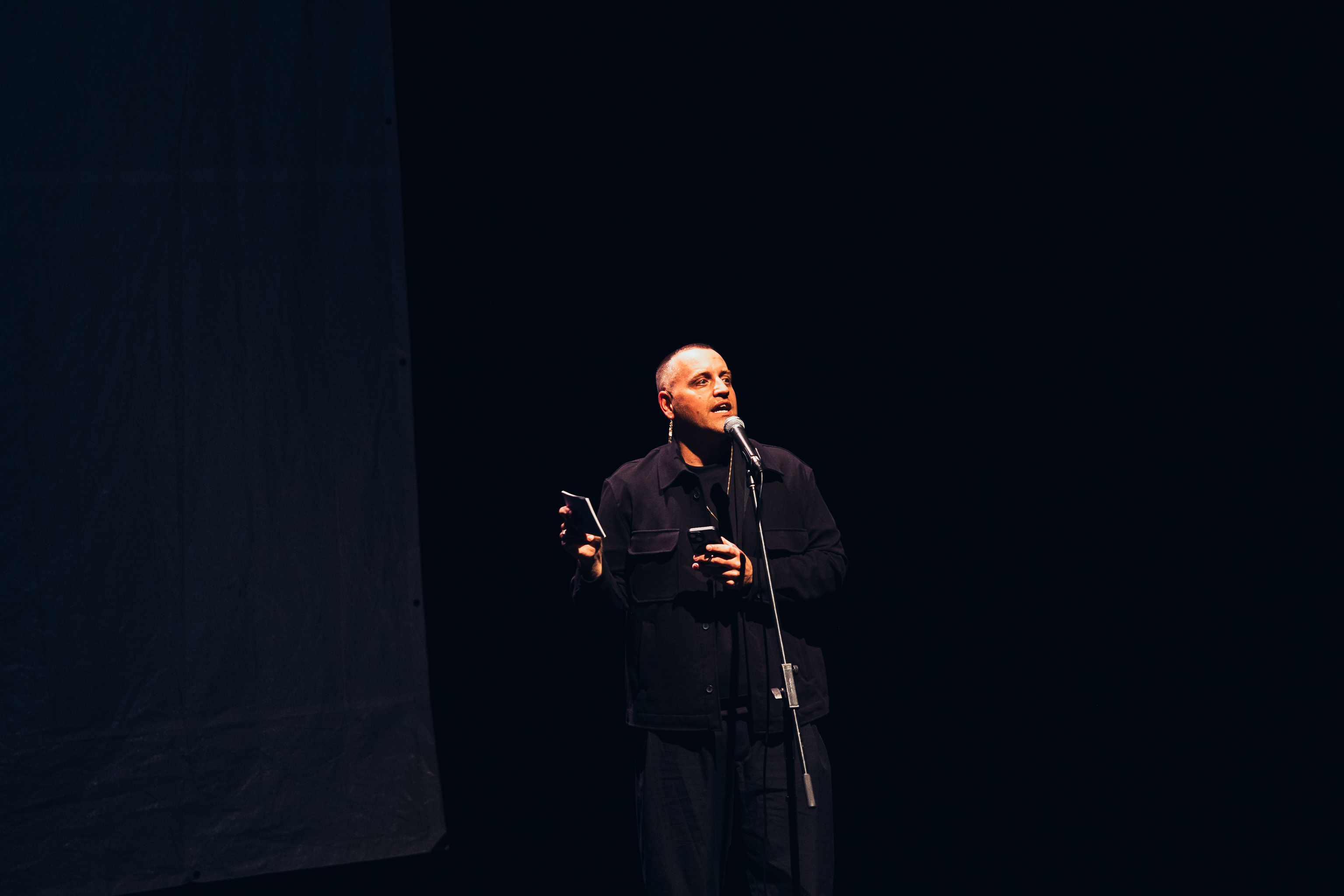 Stewart Legere, speaking into a microphone on a mic stand.