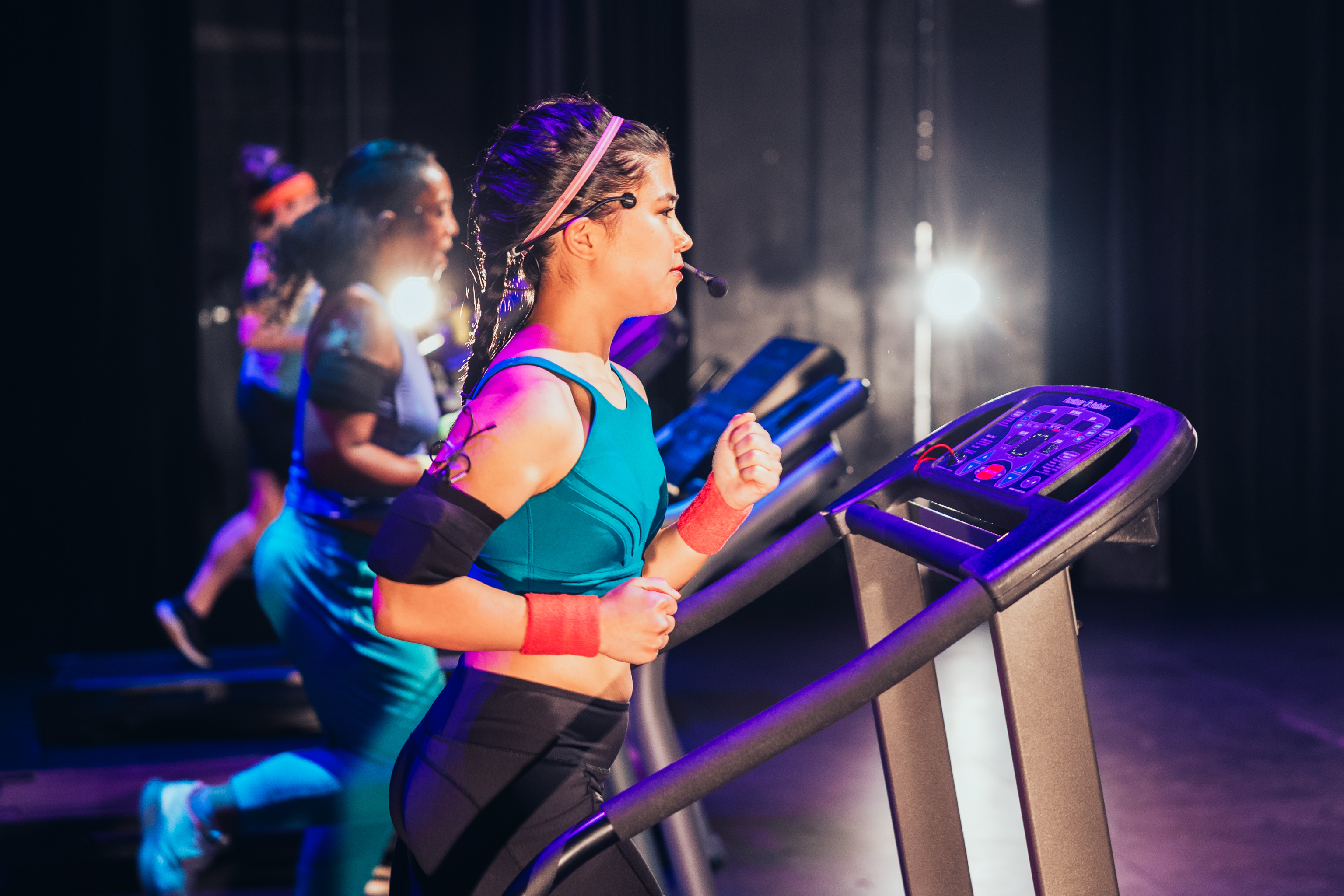 Four performers running on treadmills. 