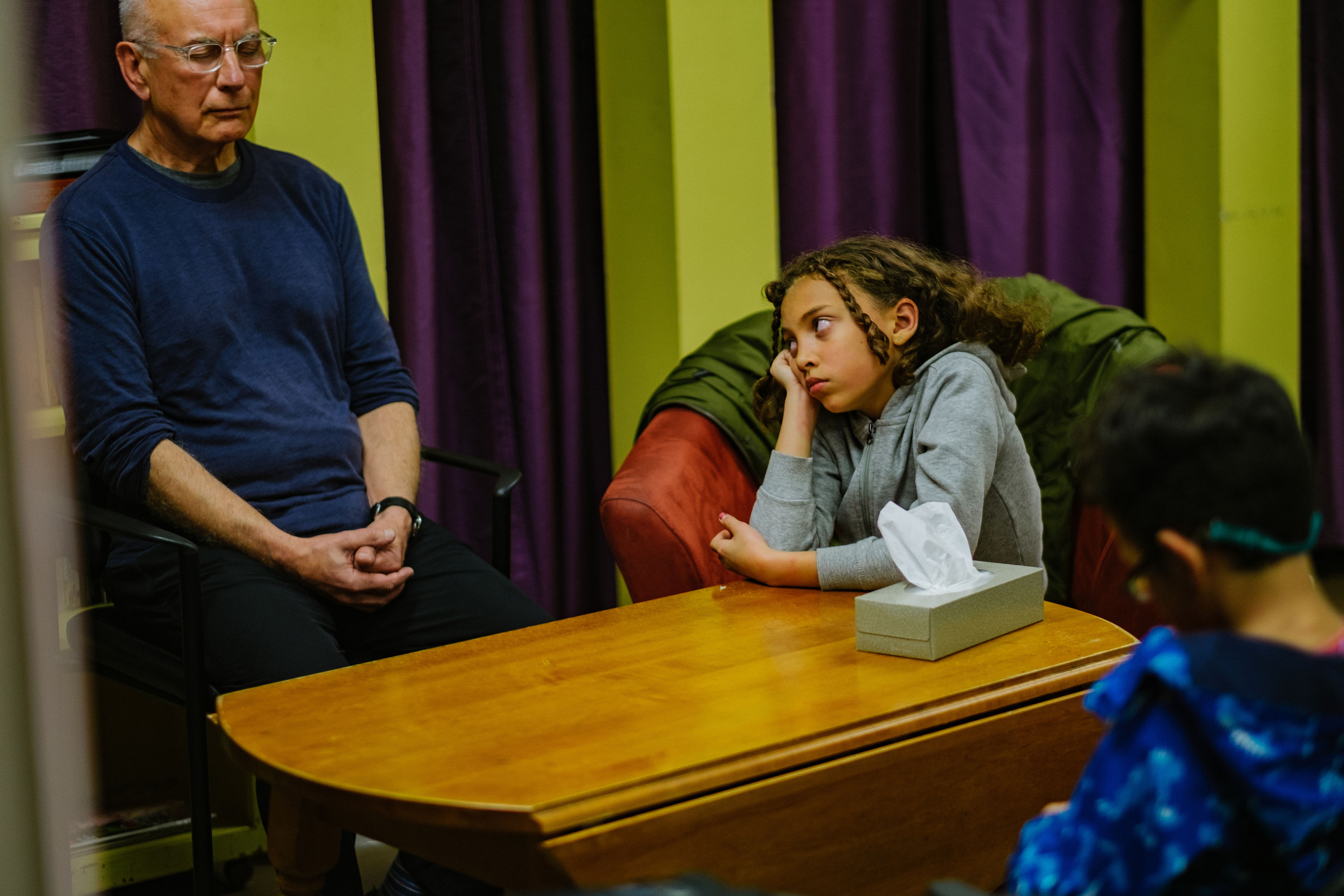 Grandfather and granddaughter in a seniors' centre waiting room. 