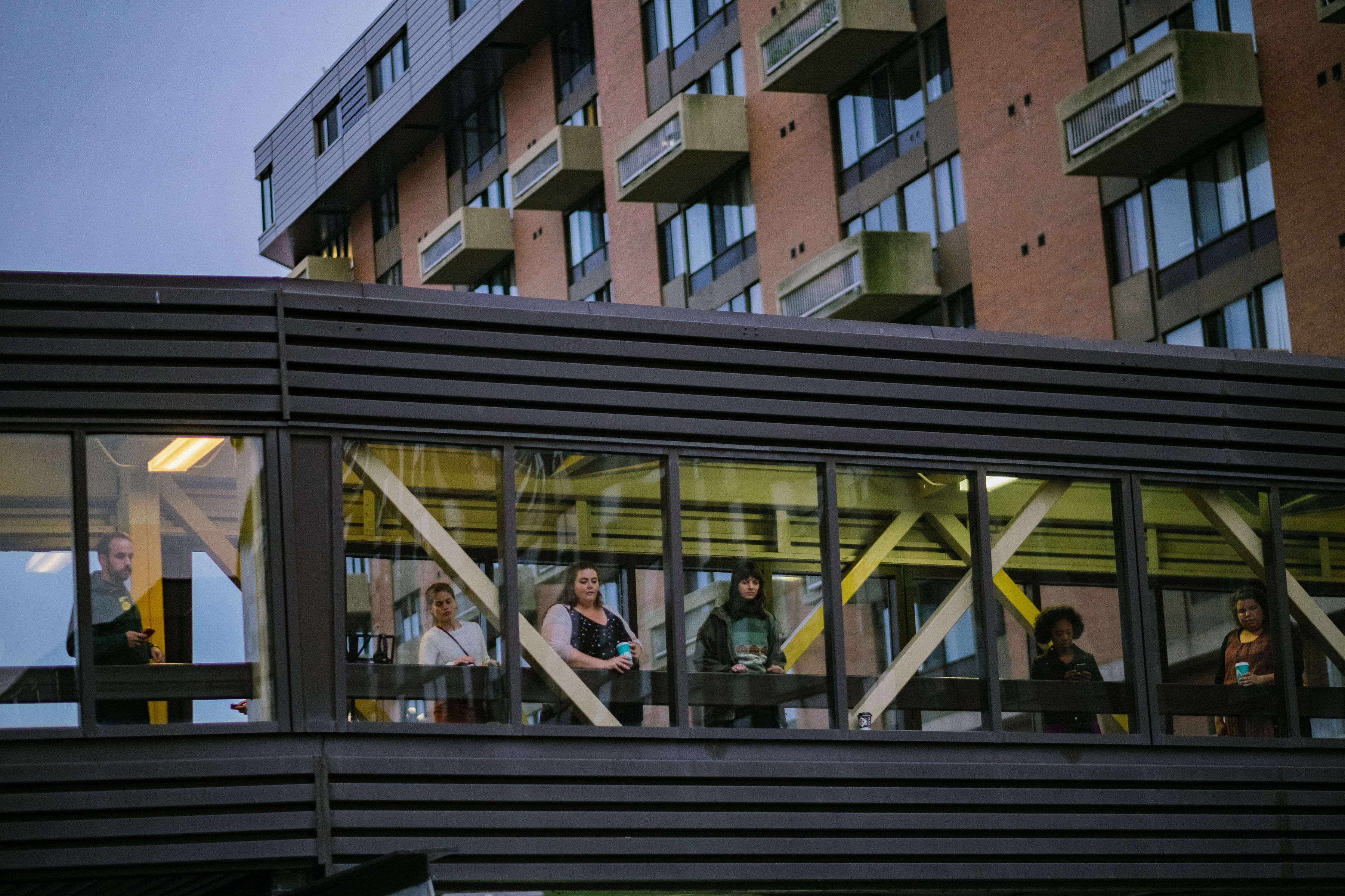 Audience watching a street scene from a pedway.