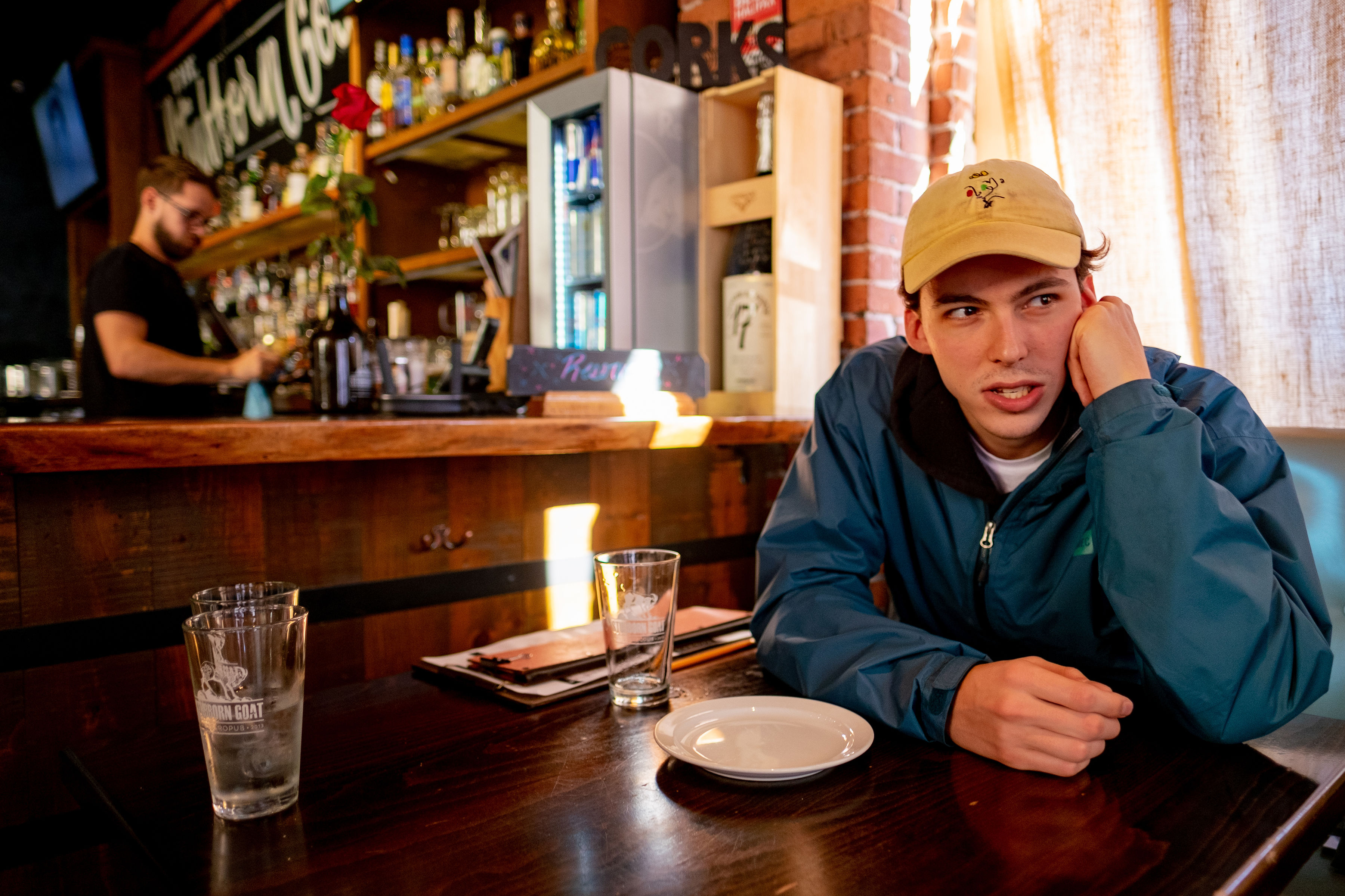 A disgruntled man sits at a table in a pub.