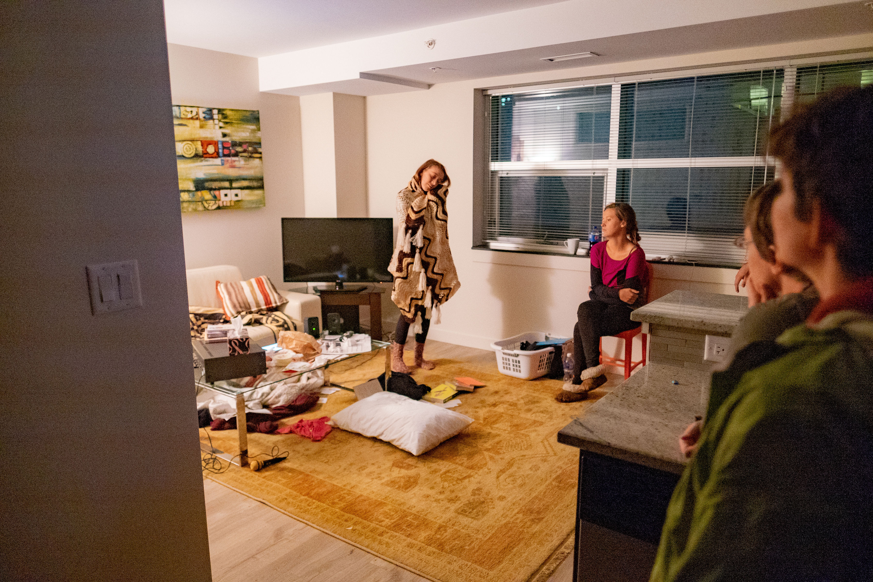 An upset woman makes a recording in her apartment.